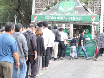 Personel Kodim 0507/Bekasi bersama Persit KCK Cabang XXI Koorcab Rem 051 PD Jaya melakukan pembagian nasi kotak untuk jemaah sholat Jum'at dalam rangka Jumat berkah