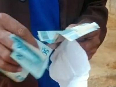 Tangkapan layar video KPM sedang menghitung uang bantuan yang diterimanya dari pemerintah. Dalam video ini ada percakapan warga yang menyebut bantuan disunat Rp 20.000 oleh oknum kepala desa dan ketua PKH