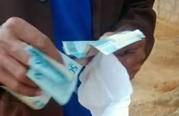 Tangkapan layar video KPM sedang menghitung uang bantuan yang diterimanya dari pemerintah. Dalam video ini ada percakapan warga yang menyebut bantuan disunat Rp 20.000 oleh oknum kepala desa dan ketua PKH